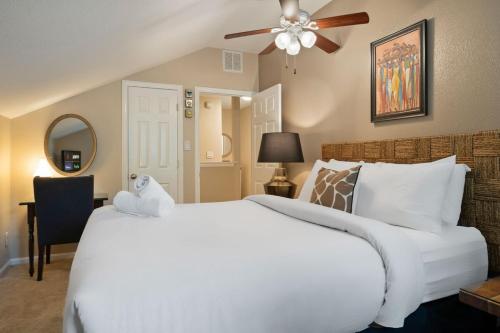 a bedroom with a large white bed with a ceiling fan at Pool Hot Tub Parking EV Charger 4BR 3BA N Austin Getaway by Austin Vacay in Austin
