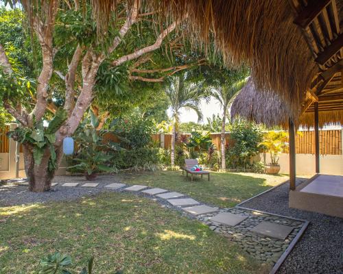 a garden with a bench and a tree at Halamanan Residences in Panglao