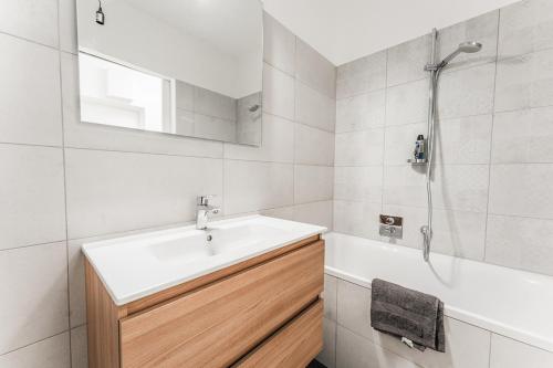 a white bathroom with a sink and a shower at Smart Living 3100 in Sankt Pölten