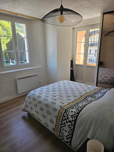 une chambre avec un lit et deux fenêtres dans l'établissement Évasion à Luz, à Luz-Saint-Sauveur