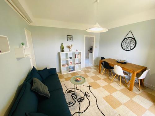 un salon avec un canapé bleu et une table dans l'établissement Bright and spacious 1 bedroom apartment with sofa bed in living room , French Riviera, à Saint-Laurent-du-Var