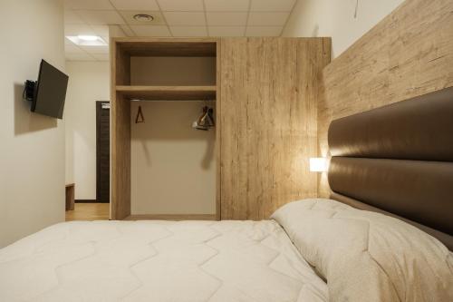 a bedroom with a bed and a wooden wall at Hotel Ristorante Da Tonino in Recanati