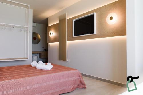 a bedroom with a bed and a flat screen tv at HOTIDAY Apartment Collection - Torre Lapillo in Porto Cesareo