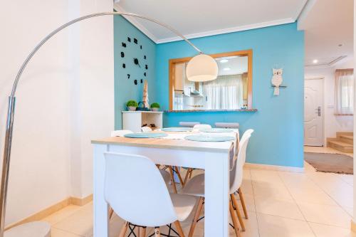 a dining room with a white table and white chairs at Duplex Torre La Sal Magic World in Cabanes