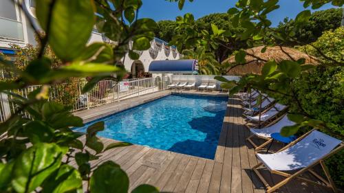 une piscine avec des chaises longues à côté d'une maison dans l'établissement Hotel Europe, à La Grande Motte