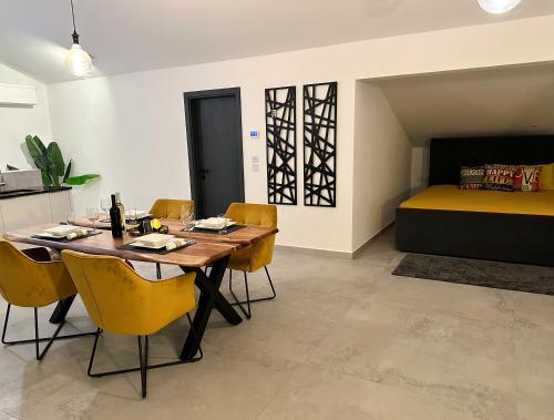a dining room with a table and chairs and a bed at Double pleasure - two apartments with sea views and pool in Komarna