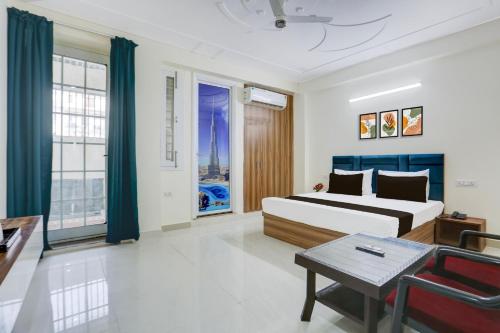 een slaapkamer met een bed en een tafel en een aantal ramen bij Hotel O THE AEROSITY in New Delhi