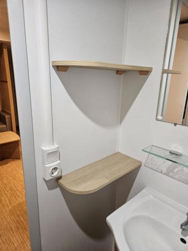 une salle de bain blanche avec un lavabo et des toilettes dans l'établissement mobil-home 6 personnes chez maylia, à Cadenet
