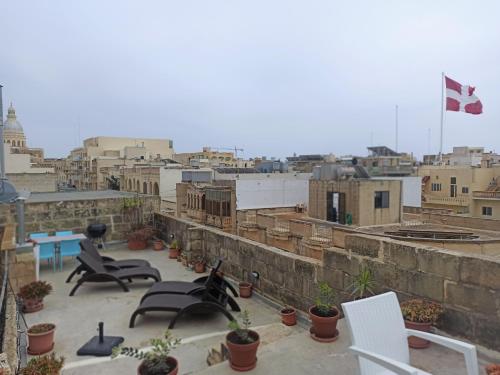 a balcony with chairs and a view of a city at Gozobreak Farmhouses in Kerċem