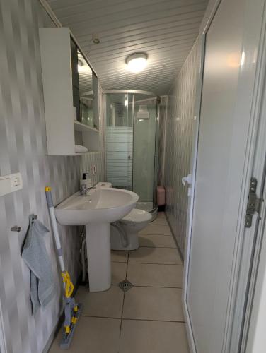 a bathroom with a sink and a toilet and a mirror at Къщички Морски Светулки in Sinemorets