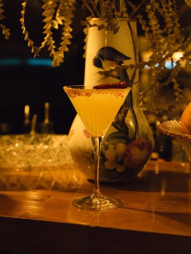 a martini glass sitting on a table with a vase at Hotel du Temps Madrid in Madrid
