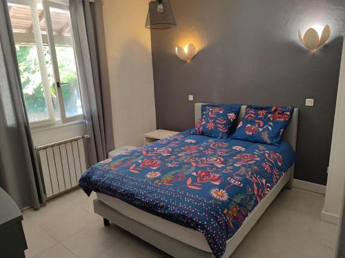 une chambre avec un lit avec une couette bleue dans l'établissement Les coquelicots, à Villeneuve-sur-Lot