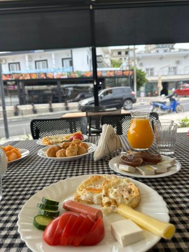 Hotel Mario في كساميل: طاولة مغطاة بأطباق الطعام وعصير البرتقال