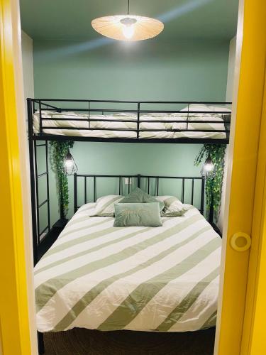 Ce lit se trouve dans un dortoir doté de lits superposés. dans l'établissement Bulle d amour, à Granville