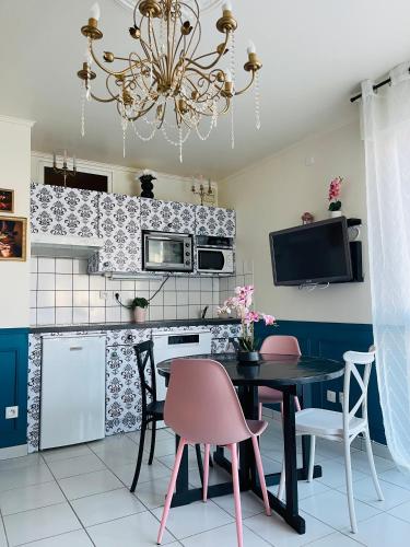 une cuisine avec une table et des chaises ainsi qu'un lustre dans l'établissement Bulle d amour, à Granville