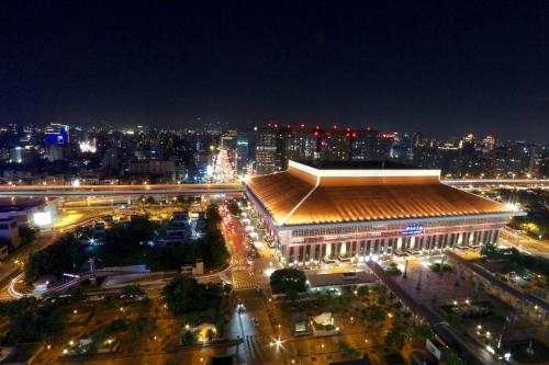 a large building with lights in a city at night at Sky19 Hotel in Taipei