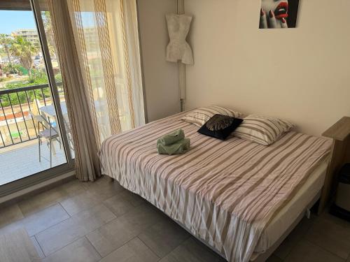 une chambre avec un lit et un balcon dans l'établissement Héliopolis J 201, au Cap d'Agde