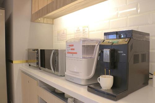a kitchen counter with a coffee maker and a microwave at Sky19 Hotel in Taipei