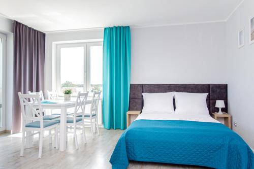 a bedroom with a bed and a table with chairs at Willa Aisza in Jastrzębia Góra