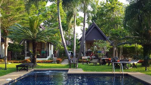 a house with a swimming pool in front of a house at Prachuap Garden View Resort in Prachuap Khiri Khan