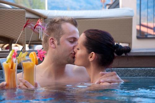 a man and woman kissing in a swimming pool at Alpen-Herz Romantik & Spa - Adults Only in Ladis