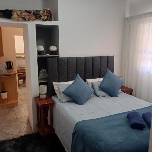 Un dormitorio con una cama grande con almohadas azules. en Linga Longa, en Beaufort West