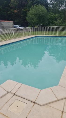 une piscine d'eau bleue et une clôture dans l'établissement chez Jordan logement Mirepoix 09 Vacance, à Mirepoix