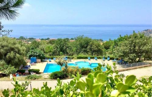 a resort with a swimming pool and the ocean at 1 Bedroom Lovely Apartment In Ricadi in Ricadi