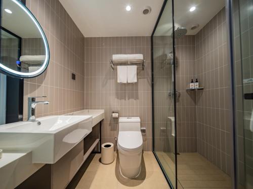 a bathroom with a toilet and a sink and a shower at Jinjiang Inn Xi'an High-tech Zone Electronic City Flagship in Xi'an