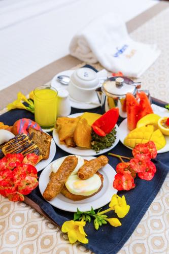 a table with plates of food on a table at PrideInn Hotel Diani in Diani Beach