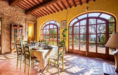 Un comedor con mesa y sillas y ventanas. en Awesome Home In Capraia E Limite, en Capraia e Limite