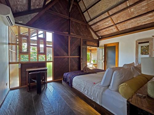 a bedroom with a large bed and a fireplace at Apalagi Villas in Gili Air