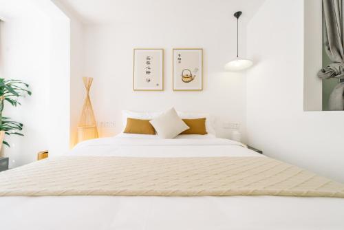 a white bedroom with a large white bed at Guan Erjie Boutique Hotel (Huimin Street of Xi'an Bell Tower ) in Xi'an