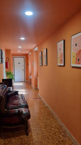 a living room with a leather couch in a hallway at BAM BAM TIBURTINA Guesthouse in Rome