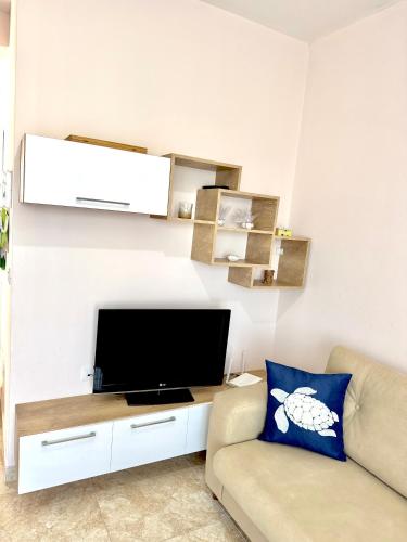 a living room with a couch and a flat screen tv at Abi Apartment Valamar in Draç