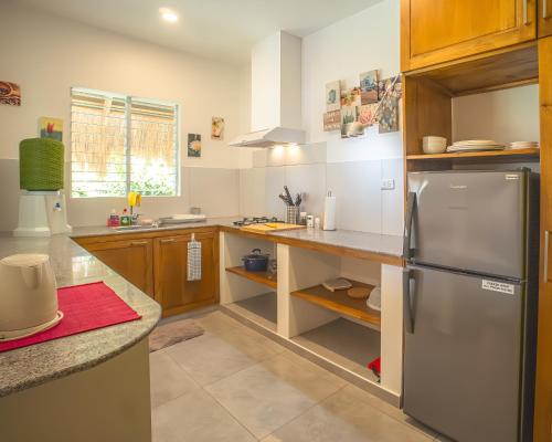 a kitchen with a stainless steel refrigerator and wooden cabinets at Halamanan Residences in Panglao