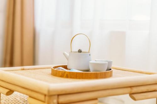 a tea pot and two cups on a wooden table at Guan Erjie Boutique Hotel (Huimin Street of Xi'an Bell Tower ) in Xi'an