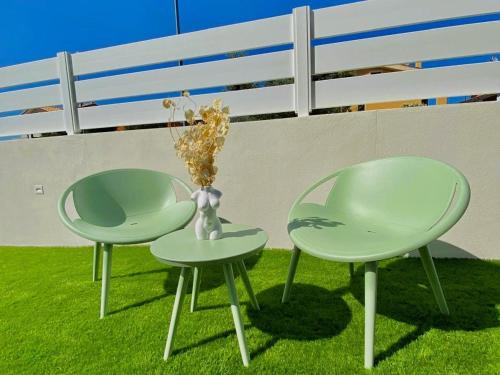 two green chairs and a vase on the grass at Calypso Luxury Pool&Spa in Pula