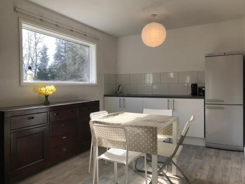 a kitchen with a table and chairs and a window at Woodland Lodge in London
