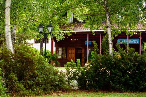 a house with a porch with trees and bushes at Kings Lodge Hotel in Hogsback