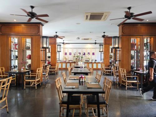a dining room with tables and chairs and ceiling fans at Buri Siri Boutique Hotel in Chiang Mai