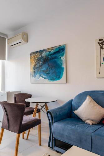 a living room with a blue couch and chairs at Stone Beach Residence - Adults Only Resort in Qeparo