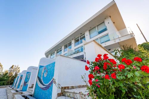 a building with red flowers in front of it at Stone Beach Residence - Adults Only Resort in Qeparo