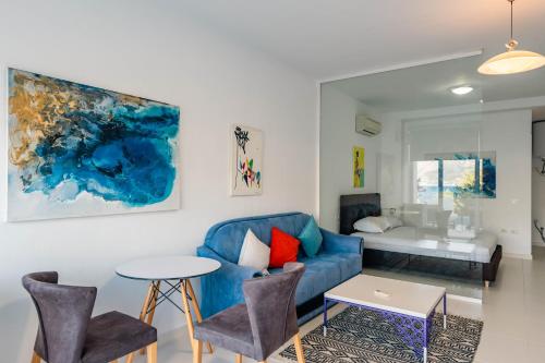 a living room with a blue couch and a table at Stone Beach Residence - Adults Only Resort in Qeparo