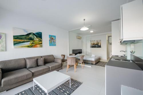 a living room with a couch and a table at Stone Beach Residence - Adults Only Resort in Qeparo