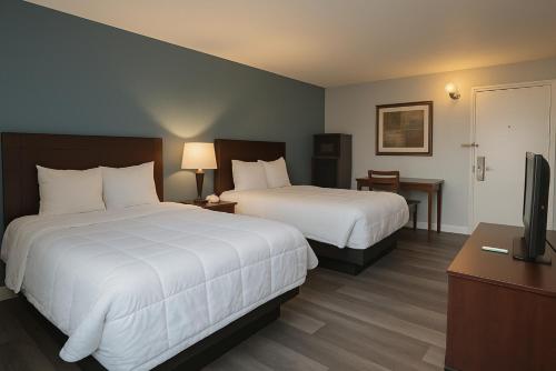 a hotel room with two beds and a flat screen tv at Key Inn Roseville in Roseville