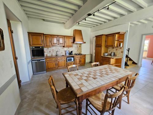 une cuisine avec une table et des chaises dans une pièce dans l'établissement Le gîte de la Rose, à Bougé-Chambalud