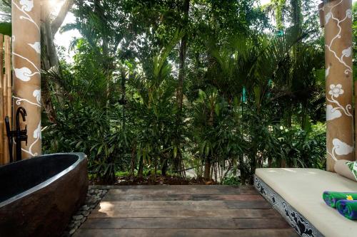 a bathroom with a bath tub and trees at Sacred Canyon Ubud by GenuineHost in Payangan