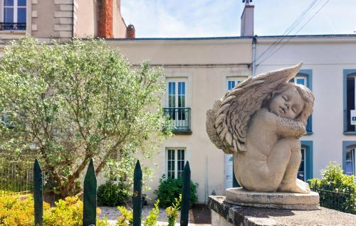 a statue of an angel sleeping in a garden at 4 Bedroom Awesome Home In Paimboeuf in Saint-Paimboeuf