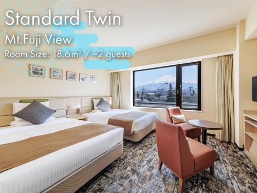 a hotel room with two beds and a window at HOTEL MYSTAYS Fuji Onsen Resort in Fujiyoshida